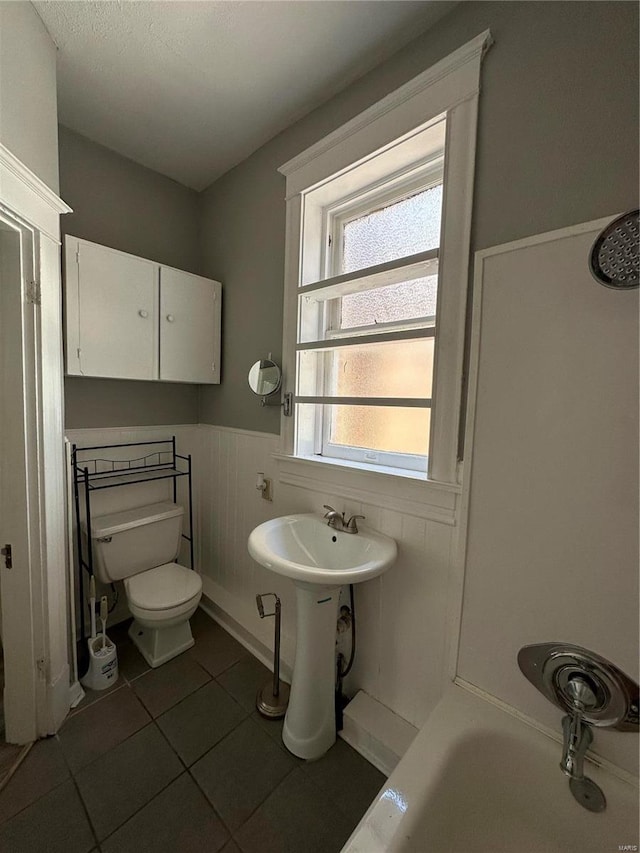 bathroom with sink, tile patterned floors, a bathing tub, and toilet