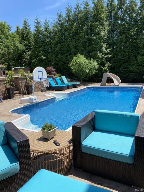 view of pool with a patio and a water slide