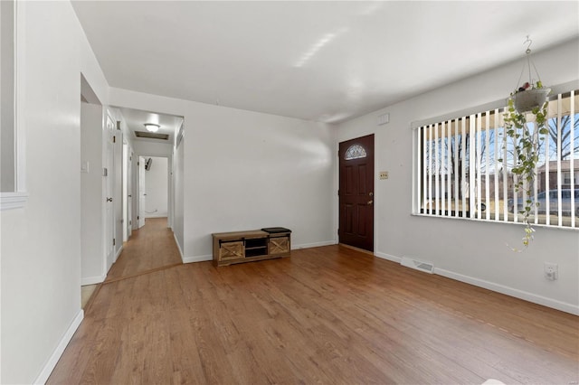 entryway featuring visible vents, baseboards, and wood finished floors