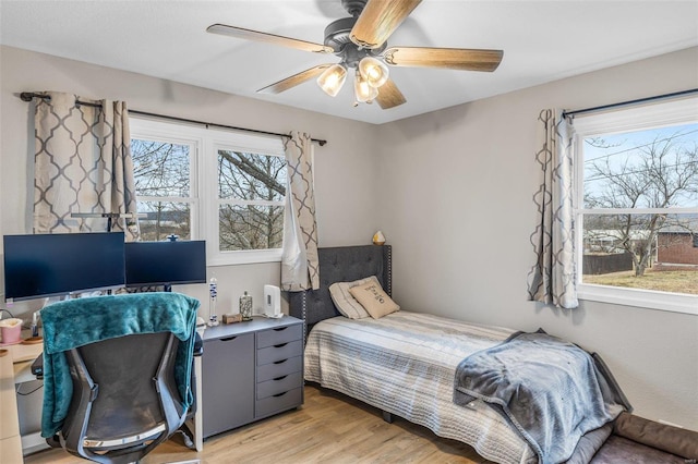 bedroom featuring multiple windows, light hardwood / wood-style floors, and ceiling fan