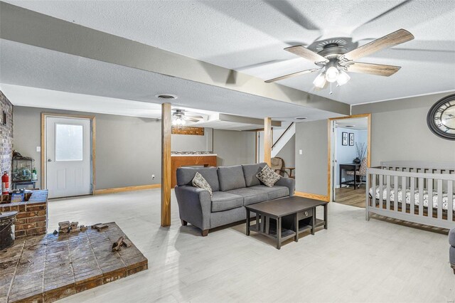 living room featuring wood-type flooring, a textured ceiling, and ceiling fan