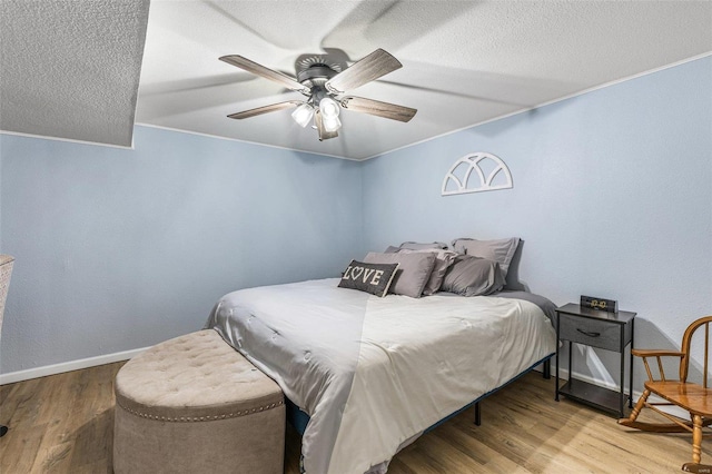 bedroom featuring hardwood / wood-style flooring, ornamental molding, and ceiling fan