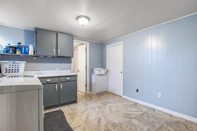 laundry area featuring cabinets and a textured ceiling