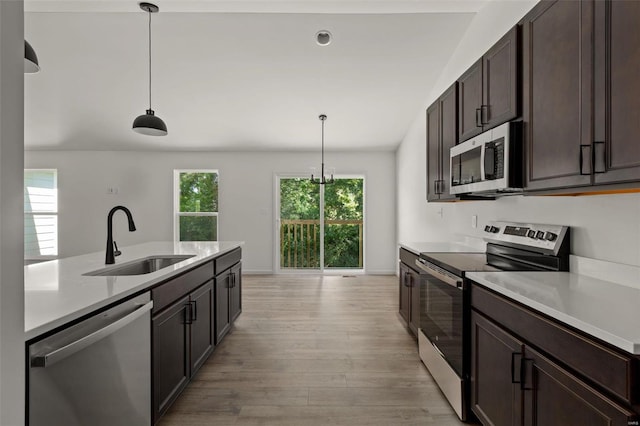 kitchen with pendant lighting, sink, stainless steel appliances, and a healthy amount of sunlight