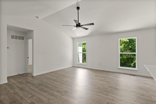 spare room with ceiling fan, lofted ceiling, and light wood-type flooring