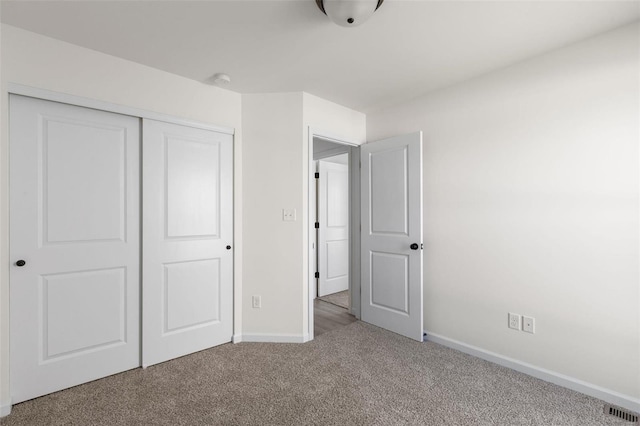 unfurnished bedroom featuring carpet flooring and a closet