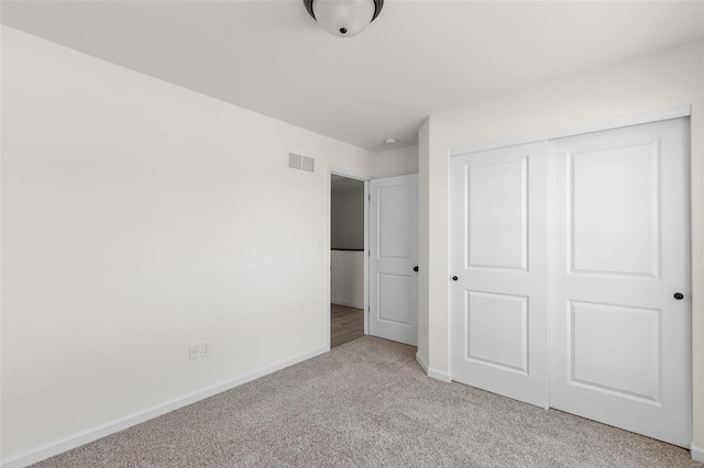 unfurnished bedroom with light carpet and a closet