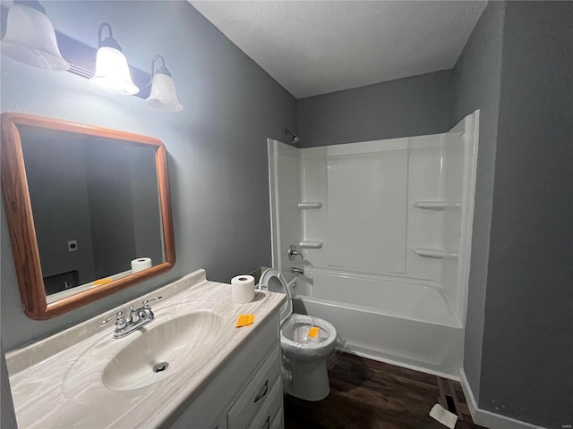 full bathroom featuring  shower combination, toilet, wood-type flooring, and vanity