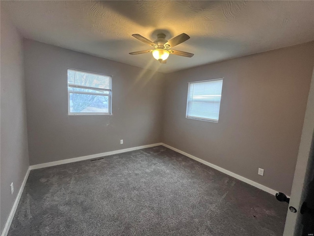 carpeted empty room featuring ceiling fan and a textured ceiling