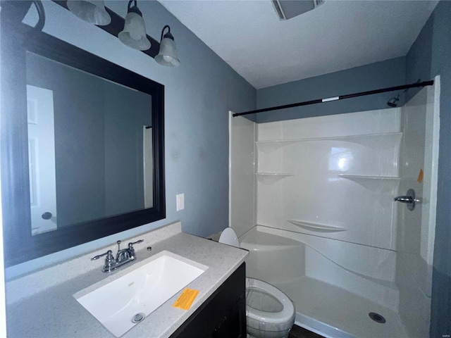 bathroom with vanity, toilet, and walk in shower