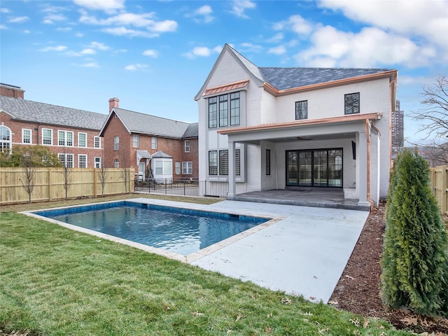 back of property featuring a fenced in pool, a patio, fence, a yard, and stucco siding