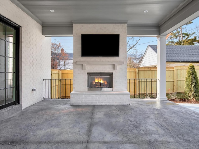 view of patio / terrace featuring an outdoor brick fireplace and fence