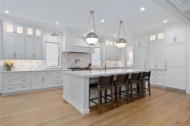 kitchen featuring white cabinetry, glass insert cabinets, and light countertops