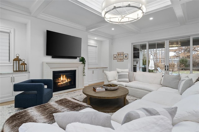 living area with beam ceiling, a glass covered fireplace, wood finished floors, a chandelier, and coffered ceiling