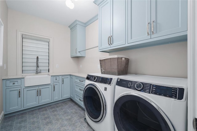 laundry area with cabinet space, separate washer and dryer, and a sink