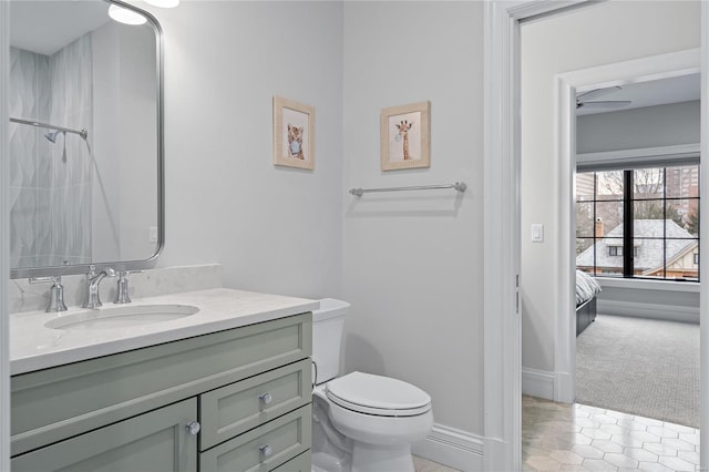 full bath featuring baseboards, a shower, toilet, ensuite bathroom, and vanity