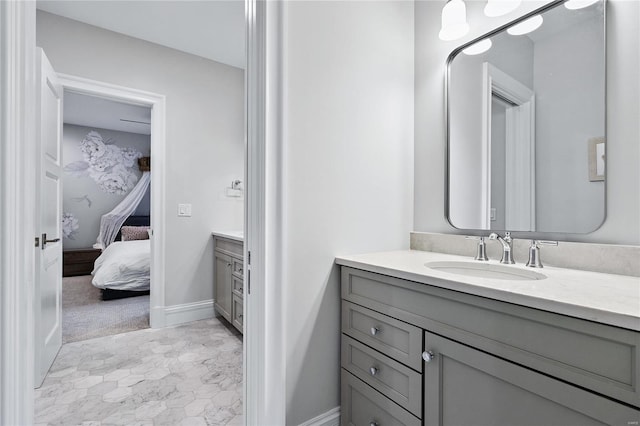 bathroom featuring baseboards, connected bathroom, and vanity