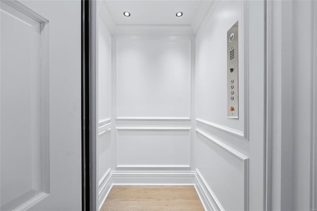 details with ornamental molding, recessed lighting, elevator, and wood finished floors