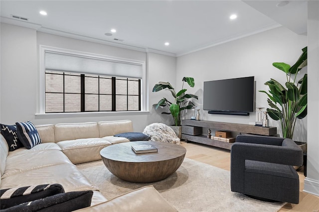 living area with light wood finished floors, recessed lighting, visible vents, and ornamental molding