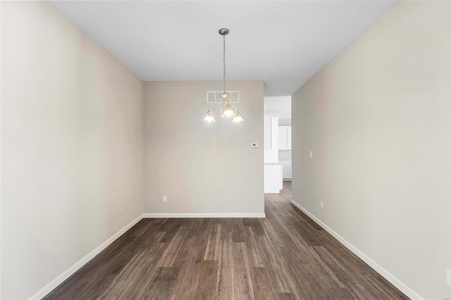 unfurnished dining area featuring a notable chandelier and dark hardwood / wood-style floors