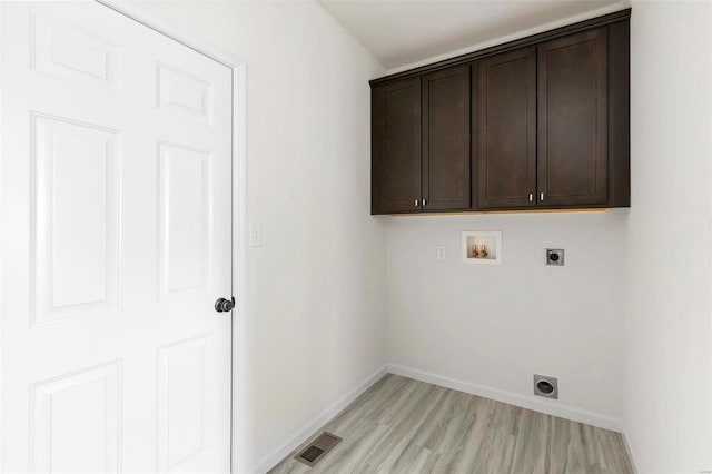 clothes washing area featuring hookup for a washing machine, electric dryer hookup, cabinets, and light hardwood / wood-style floors