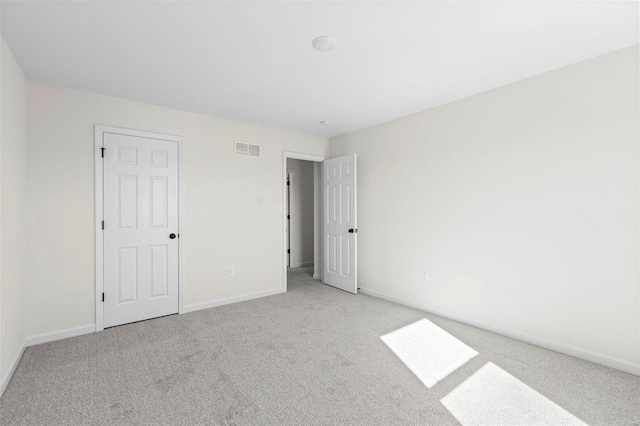 spare room featuring light colored carpet