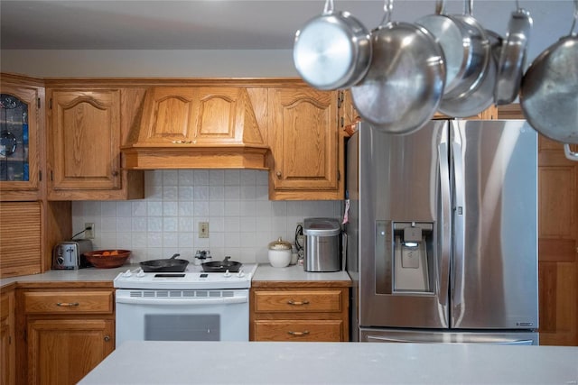 kitchen with white range with electric cooktop, premium range hood, decorative backsplash, and stainless steel fridge with ice dispenser