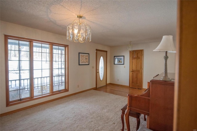 entryway with carpet flooring, a chandelier, and a textured ceiling