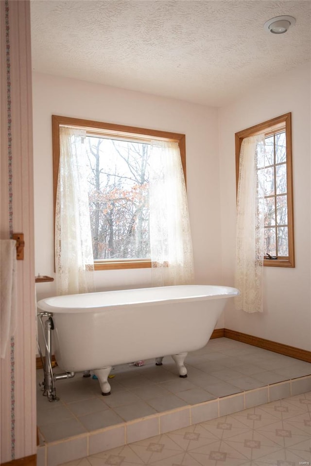 bathroom featuring a tub to relax in and a textured ceiling