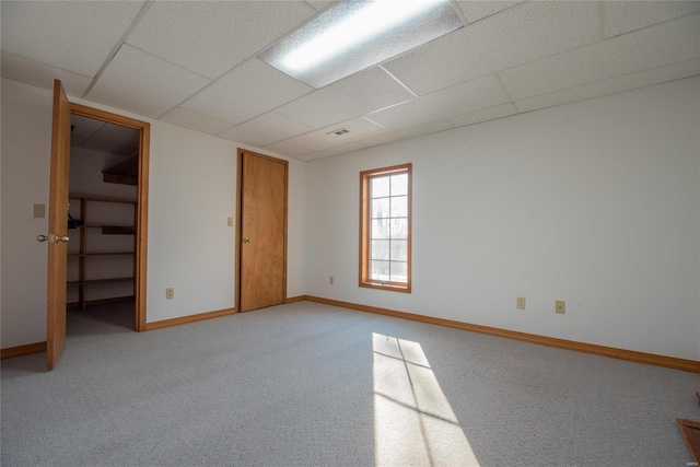 carpeted spare room with a paneled ceiling