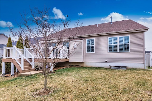 back of property featuring a deck and a lawn