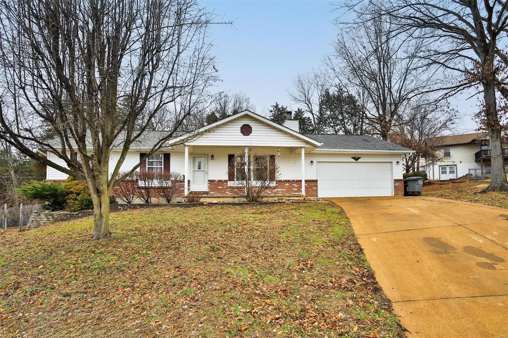 single story home featuring a garage, a front yard, and covered porch