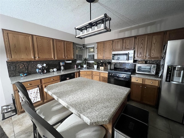 kitchen featuring a breakfast bar, sink, decorative backsplash, and black appliances