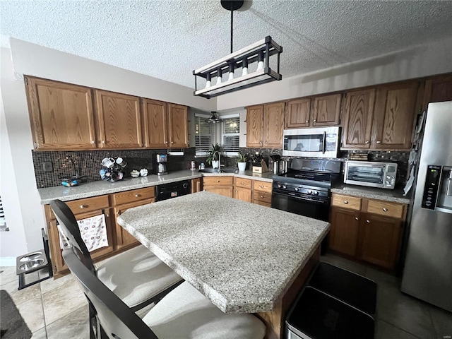 kitchen featuring tasteful backsplash, a breakfast bar, sink, and black appliances