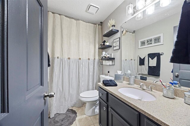 bathroom featuring curtained shower, tile patterned flooring, vanity, toilet, and a textured ceiling