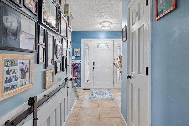 tiled entryway with a textured ceiling