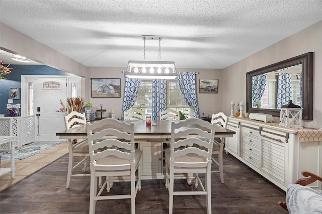 dining room featuring a healthy amount of sunlight, dark hardwood / wood-style floors, and a textured ceiling