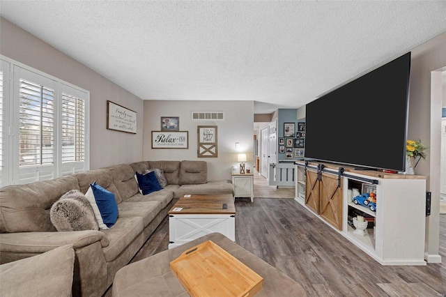 living room featuring wood-type flooring and a textured ceiling