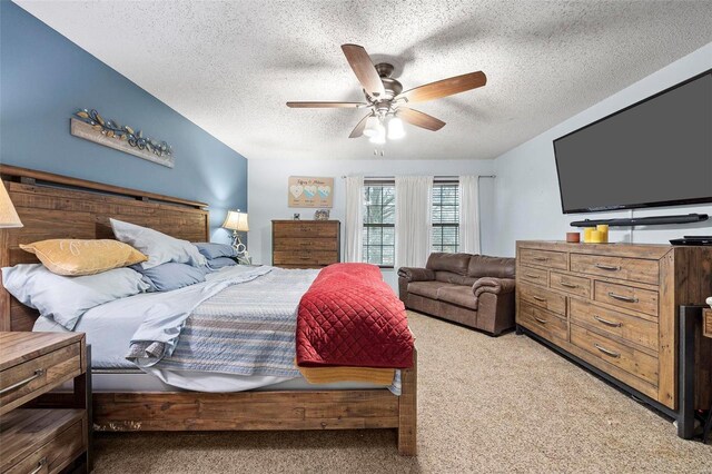 carpeted bedroom with ceiling fan and a textured ceiling