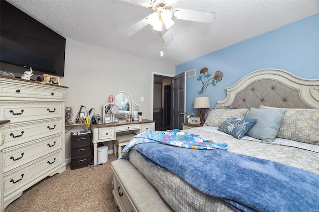 carpeted bedroom featuring ceiling fan and a textured ceiling