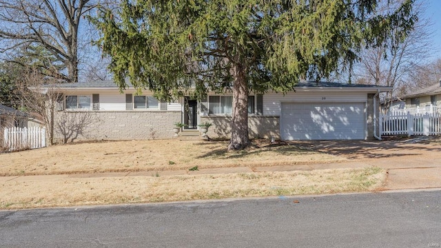 ranch-style home with driveway, an attached garage, fence, and brick siding