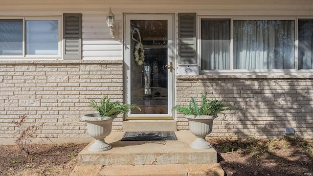 doorway to property with brick siding