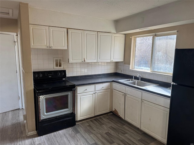 kitchen featuring tasteful backsplash, sink, dark wood-type flooring, and black appliances