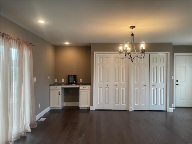 kitchen featuring hanging light fixtures, white cabinetry, dark wood-type flooring, and an inviting chandelier