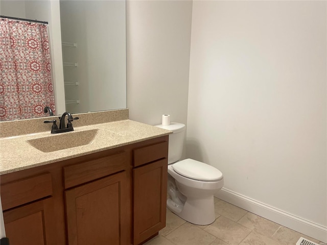 bathroom featuring vanity, tile patterned floors, and toilet