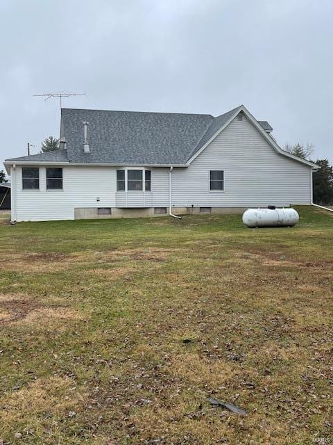 back of house with a lawn and roof with shingles