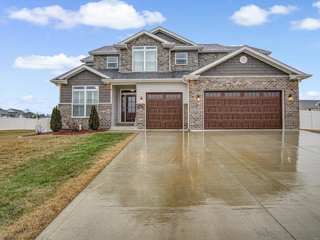 view of front facade with brick siding, fence, a garage, driveway, and a front lawn