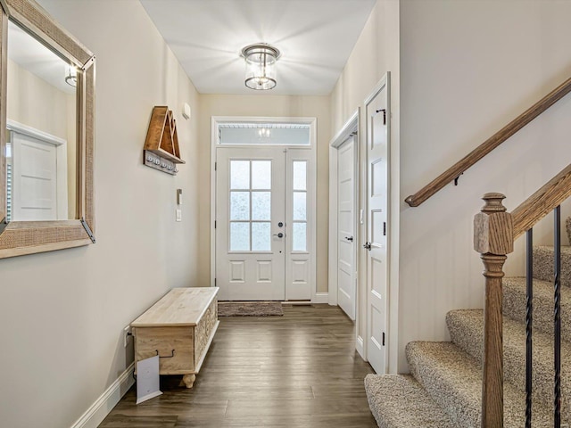 interior space featuring stairs, dark wood-type flooring, and baseboards