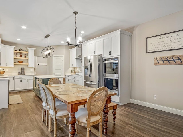 dining space featuring baseboards, a chandelier, dark wood-type flooring, and recessed lighting