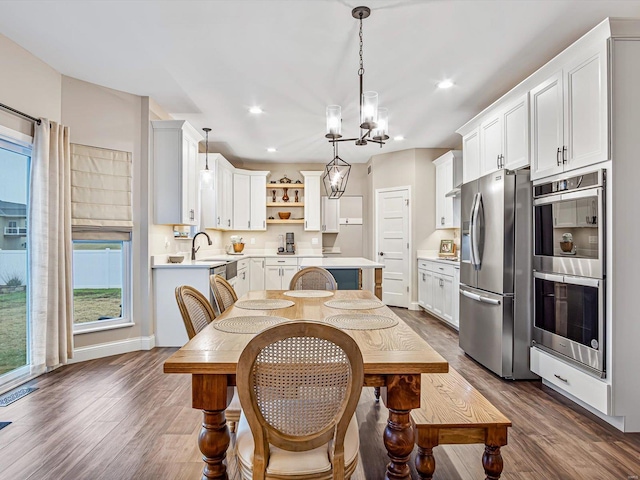 kitchen with a sink, stainless steel appliances, light countertops, and a chandelier